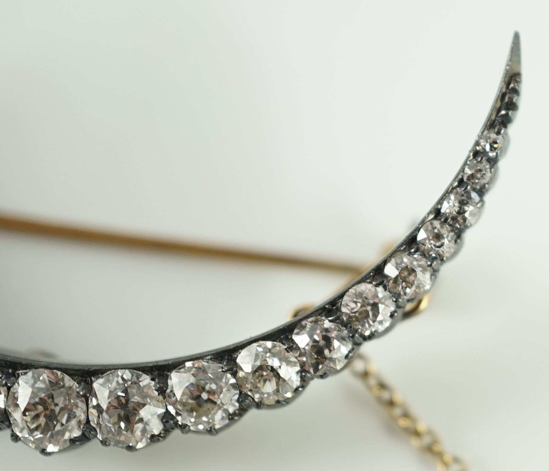 A Victorian, gold, silver and graduated twenty one stone diamond set crescent brooch
